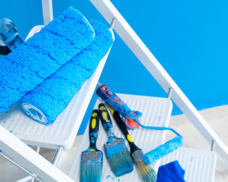 House renovation tools on white ladder, blue wall background